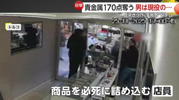 強盗犯に命令され商品をまとめる店員（IHA）