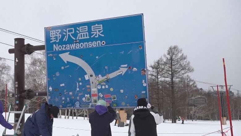 ステッカーをはがす職員ら