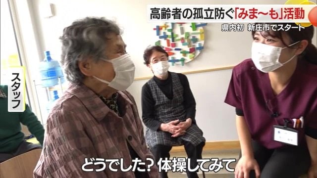 スタッフが健康体操初参加の女性に声がけをする様子