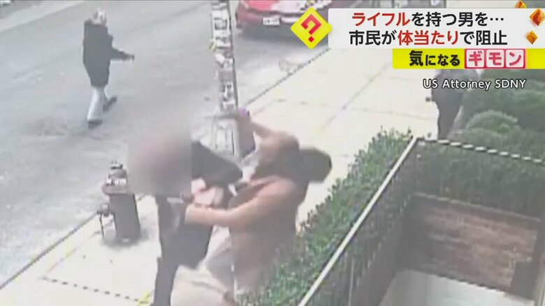 ライフルを持つ男に体当たりする男性