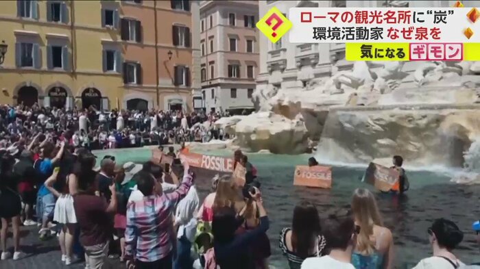 黒く濁ったトレビの泉に入り、横断幕を掲げる活動家たち