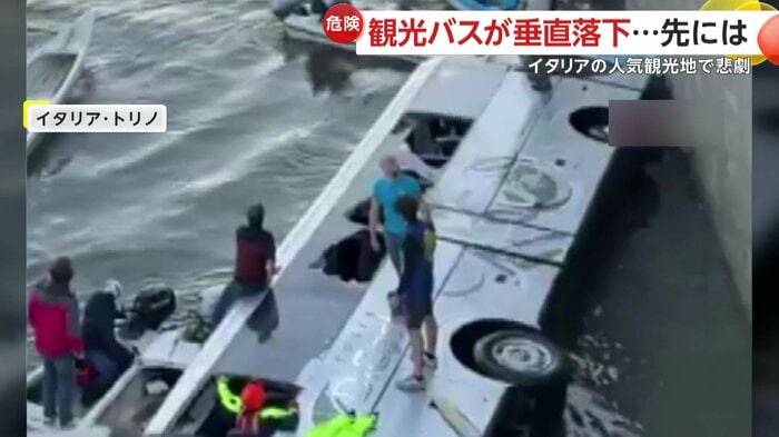 川に沈んだバスと救助活動を行う人々(IHA)