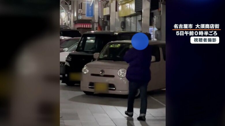 通行しようとするも、並べられた車に困惑する人
