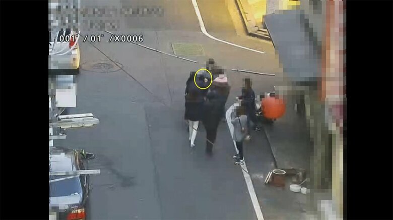 赤羽で、酔客が、店の女に囲まれてATMに誘導される。(警視庁提供)