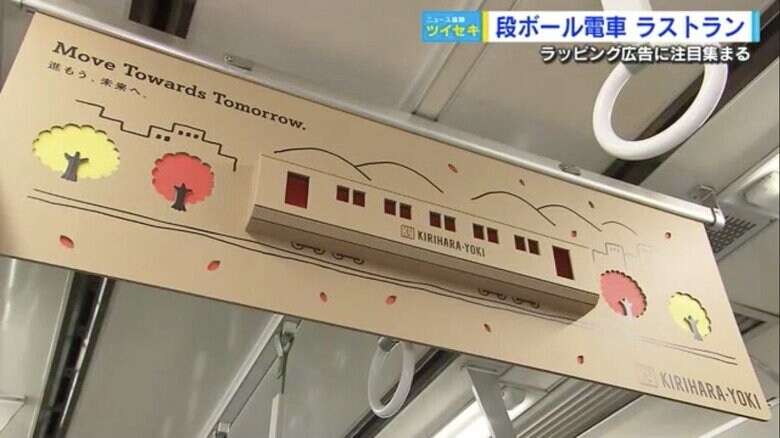 「路面電車と紅葉」を段ボールで立体的にデザインした中づり広告