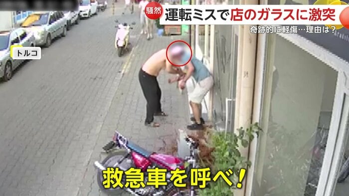 シャツで手当てする通行人とケガをした男性