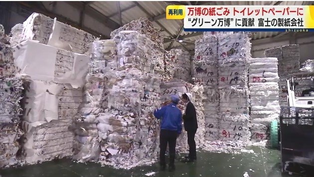 古紙の前に立つ佐野副社長と村田記者