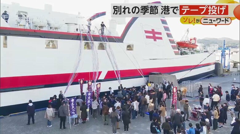 船上と地上を紙製のカラフルなテープがつなぐ