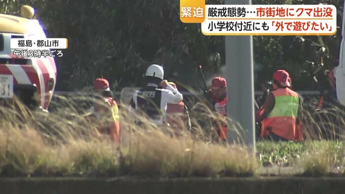 耳をふさぐ警察らの周りに白い煙が漂う