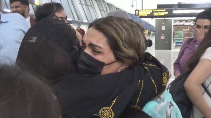 抱き合って再会を喜ぶアフガンの人々 (8月21日ワシントン・ダレス国際空港)