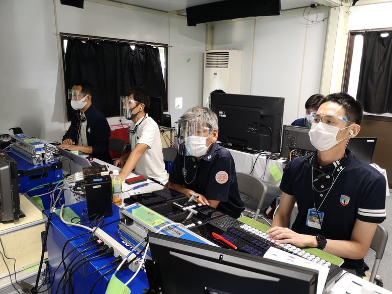 プレハブ小屋での様子 メガネ型のフェイスシールドを着用