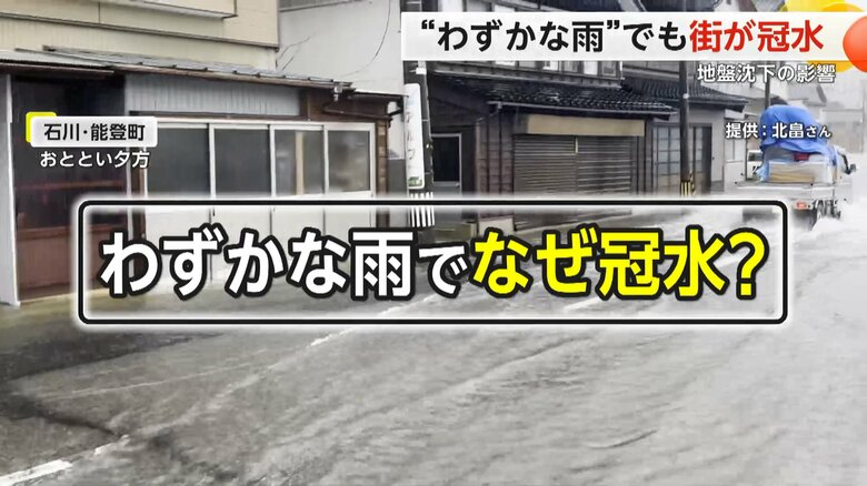 冠水し水浸しになった道路を走る軽トラック