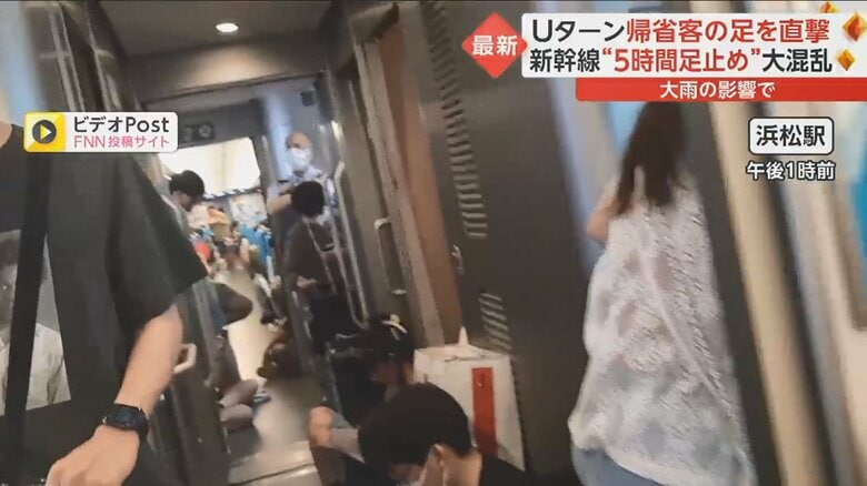 浜松駅で止まった新幹線の車内。デッキにも多くの乗客がいた。