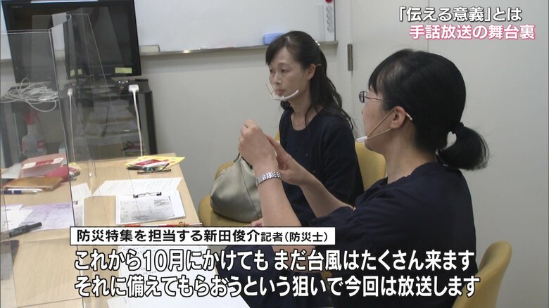 新田記者の言葉を手話に通訳する通訳者