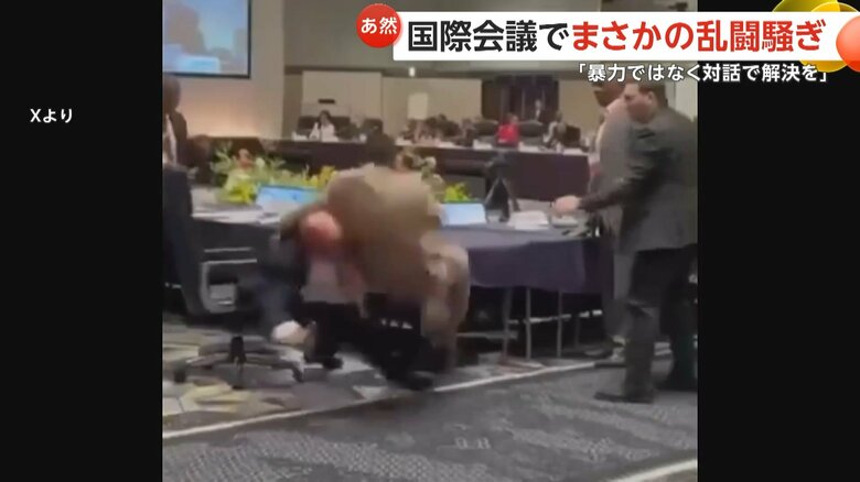 ベージュのスーツの男性を投げ飛ばす紺色のスーツの男性