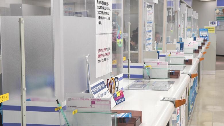 銀行窓口で困っている様子の女性が