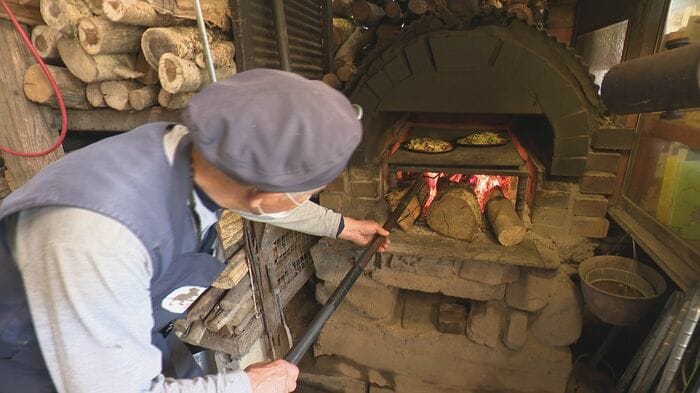 手作り窯でピザを焼く上乗さん
