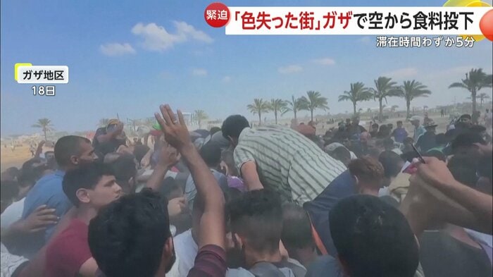 投下された支援物資に殺到する人々(18日)