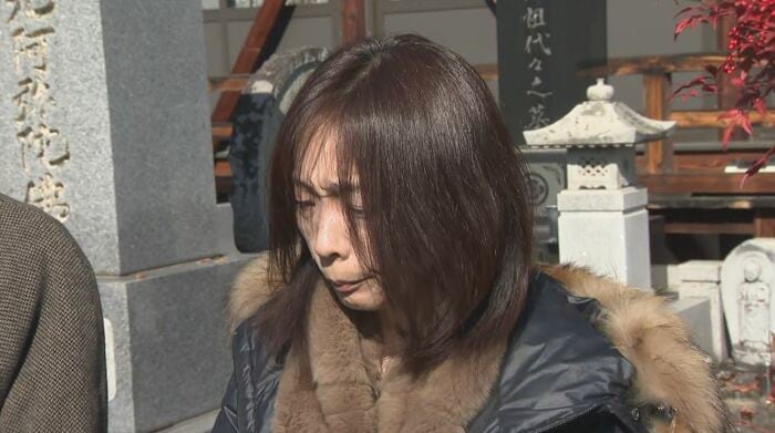樹生さんの墓の前で取材に応じる真理さん（2025年2月）