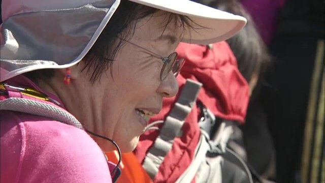 高校生と富士登山する田部井さん