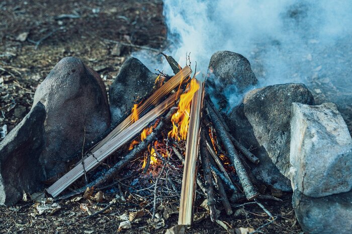 石で組んだかまど。石に熱が反射して焚き火を高温に保ち、燃焼を安定してくれる働きがある（『焚き火の教科書』より）