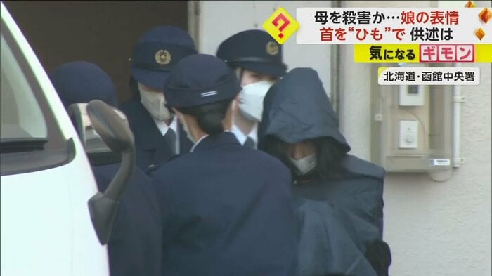 フードを被り、うつむきながら警察署から出てくる女