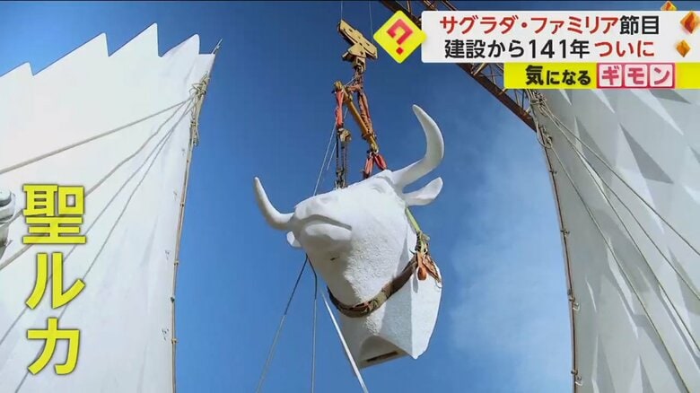 塔の頂上に運ばれた、聖ルカを表す牛の像