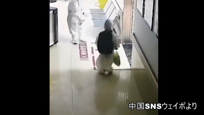 ぶかぶかの防護服を着て病院の廊下を一人で歩く4歳の男の子(中国SNSより)