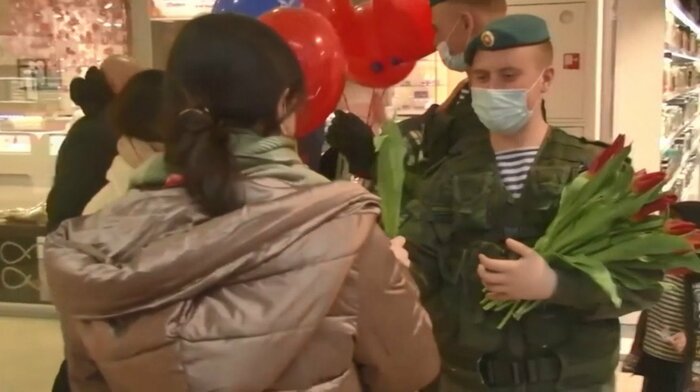 兵士たちから花束や風船を受け取る女性たち