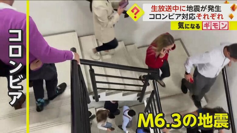 建物の階段を急いで降りて避難する人々