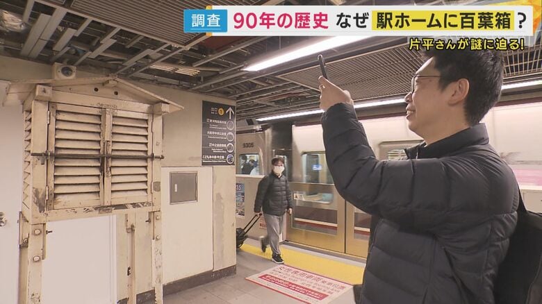 百葉箱の写真を撮る片平気象予報士