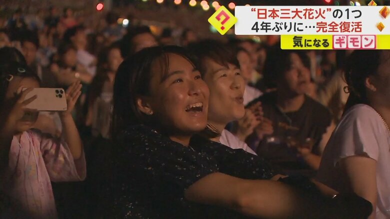 打ち上がる花火に笑顔を見せる観客たち