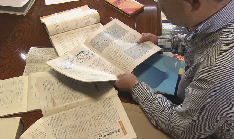 当時の参考資料を広げる上原さん