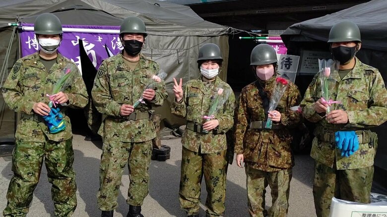 小学生から花をプレゼントされた自衛隊員
