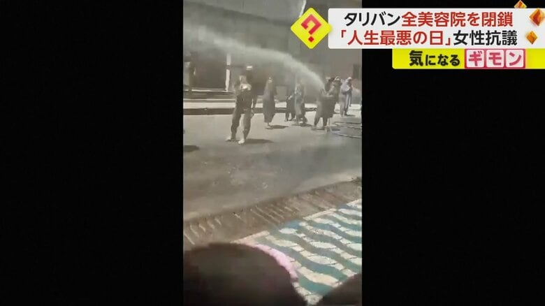 抗議者たちに放水するタリバン側の人たち