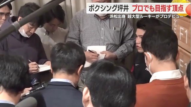 プロテスト後に報道陣に囲まれる坪井選手
