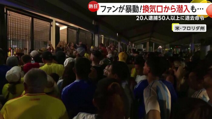 金網に押し寄せる群衆