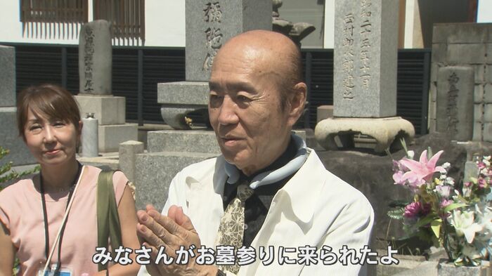 墓前に手を合わせる佐々木雅弘さん(84)