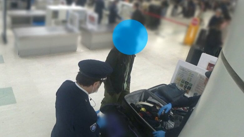 ニューヨークから来た男性の荷物を入念にチェックする税関職員