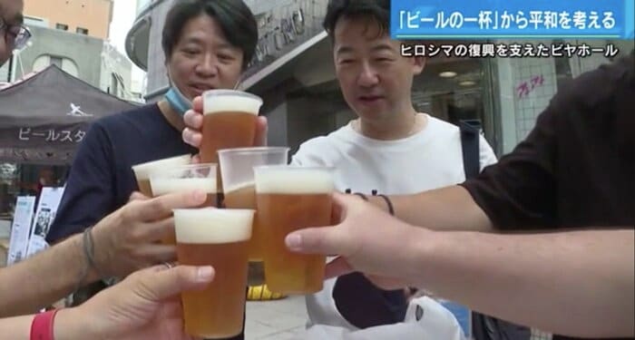 ビール片手に笑顔で乾杯するお客