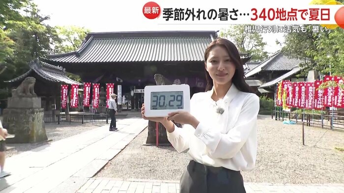 手元の温度計は30℃超え(18日、埼玉・熊谷市)
