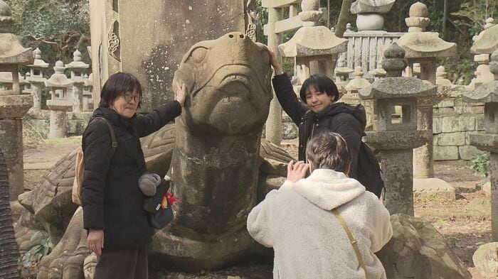 月照寺の大亀像と記念撮影をする観光客