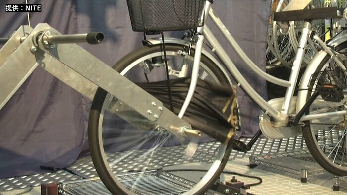 自転車で走行中に傘が挟まったことを想定した実験。先がタイヤに触れた途端、あっという間に巻き込まれてしまった(提供:NITE)