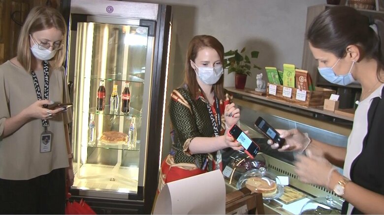 「コーナーカフェ＆キッチン」でQRコード確認後入店する女性たち