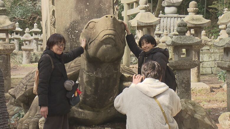 月照寺の大亀像と記念撮影をする観光客