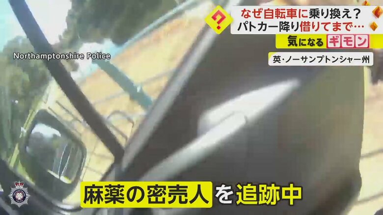 麻薬の密売人を追跡中にパトカーを降りる警察官