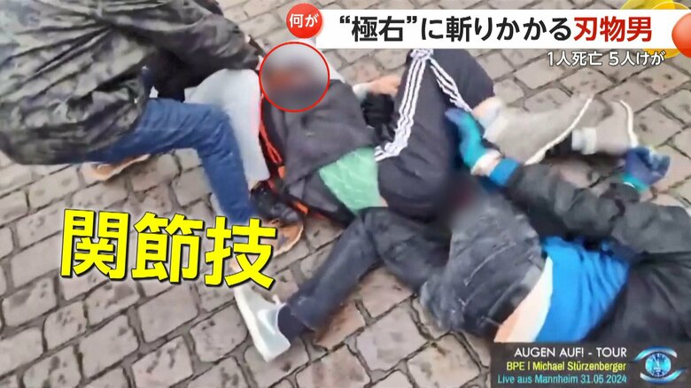 刺した人の足を押さえて関節技をかける男