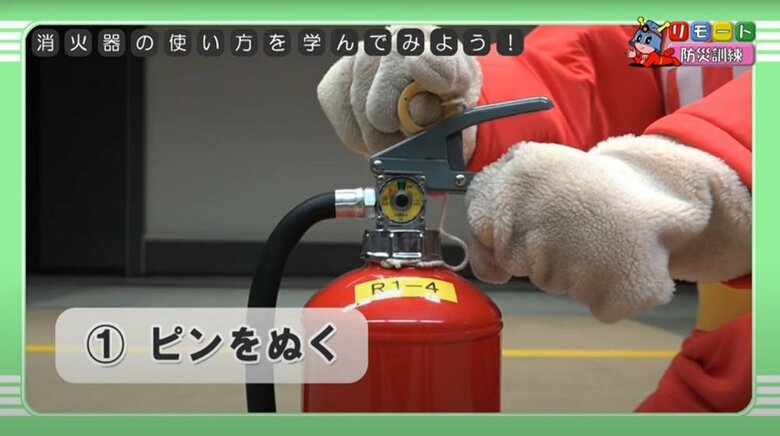 消火器の使い方（1）安全栓（ピン）を抜く（提供：東京消防庁）