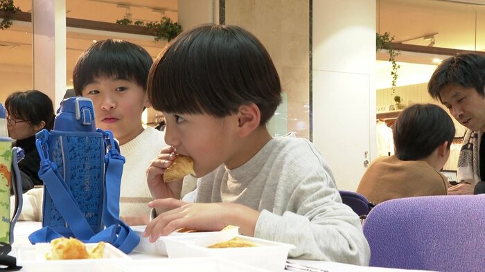 イベントで振る舞われたパンを食べる子ども