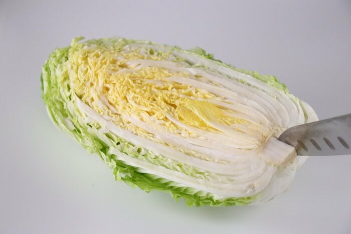 カットされた白菜は、芯の部分に切り込みを入れ、成長を止めます
